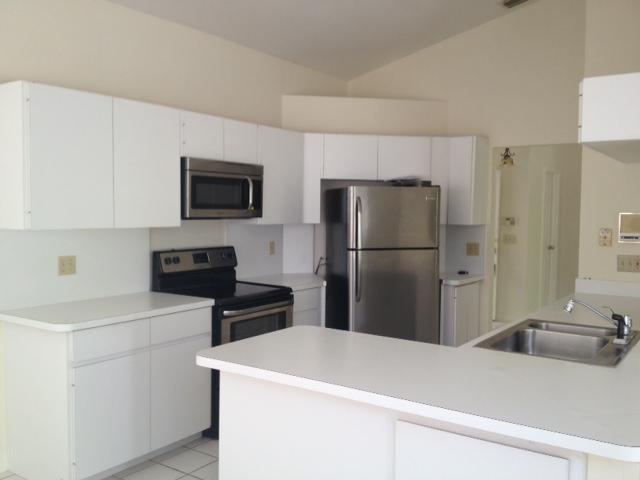 114 Colony Way East Jupiter, FL 33458 - Photo 3 of 7 a kitchen with a refrigerator and a sink
