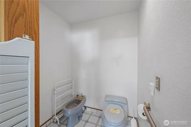 a bathroom with a granite countertop toilet and a sink