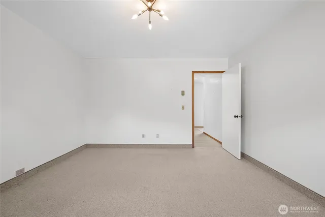 an empty room with a chandelier fan