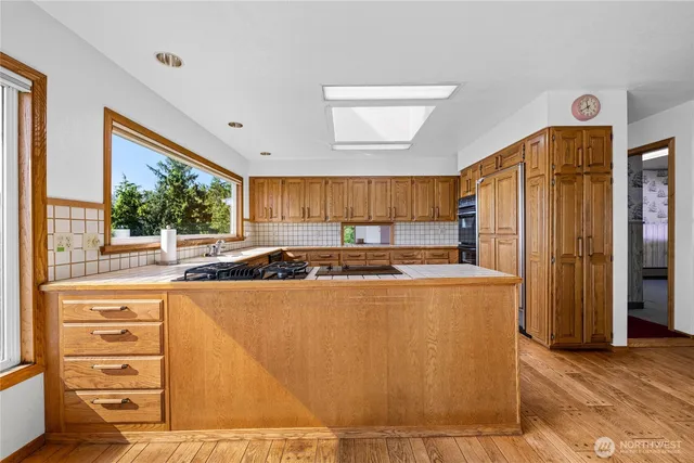 a large kitchen with stainless steel appliances granite countertop a refrigerator and a stove