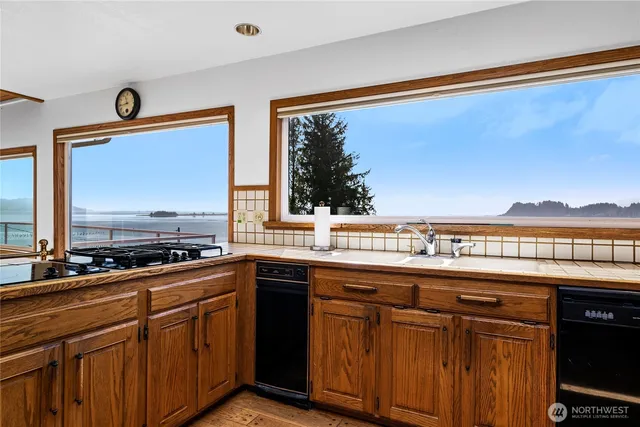 a kitchen with stainless steel appliances granite countertop a sink and wooden cabinets