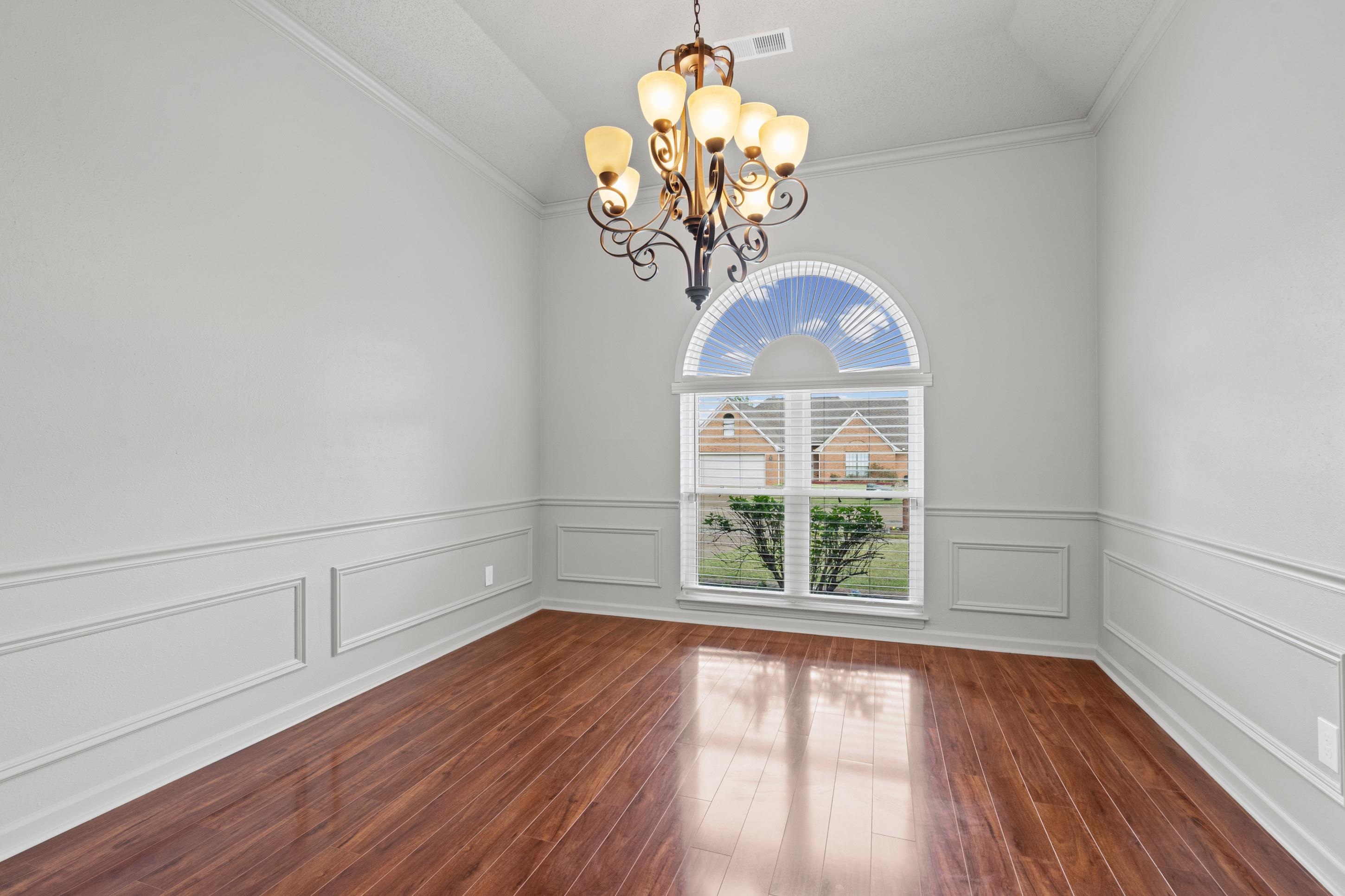 1301 Wolf Lair Drive Collierville, TN 38017 - Photo 12 of 32 Formal dining area with crown molding, suspended lighting, lofted ceiling, and dark wood finished floors
