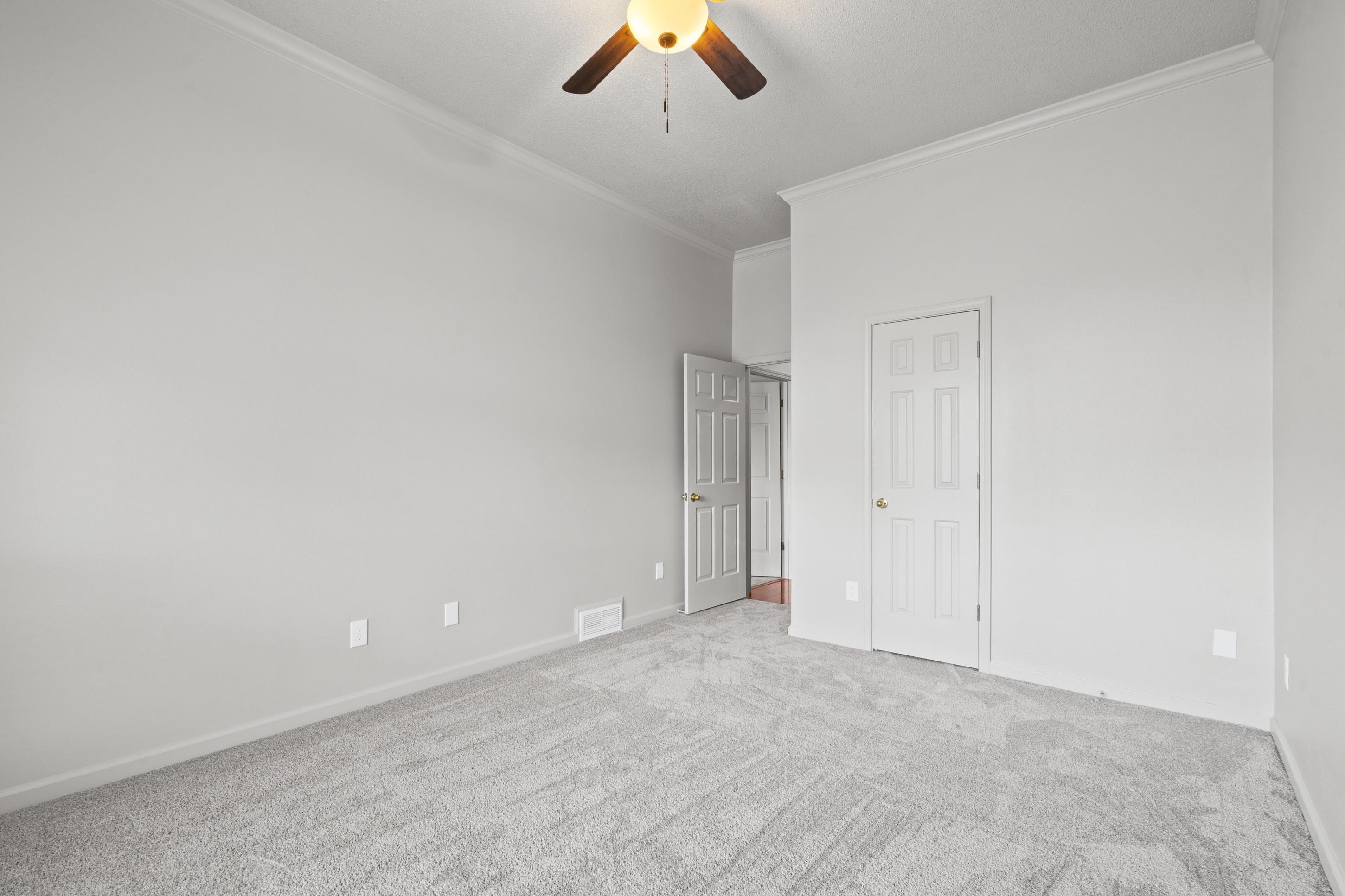 1301 Wolf Lair Drive Collierville, TN 38017 - Photo 17 of 32 Unfurnished bedroom with crown molding, light carpet, ceiling fan, and a closet