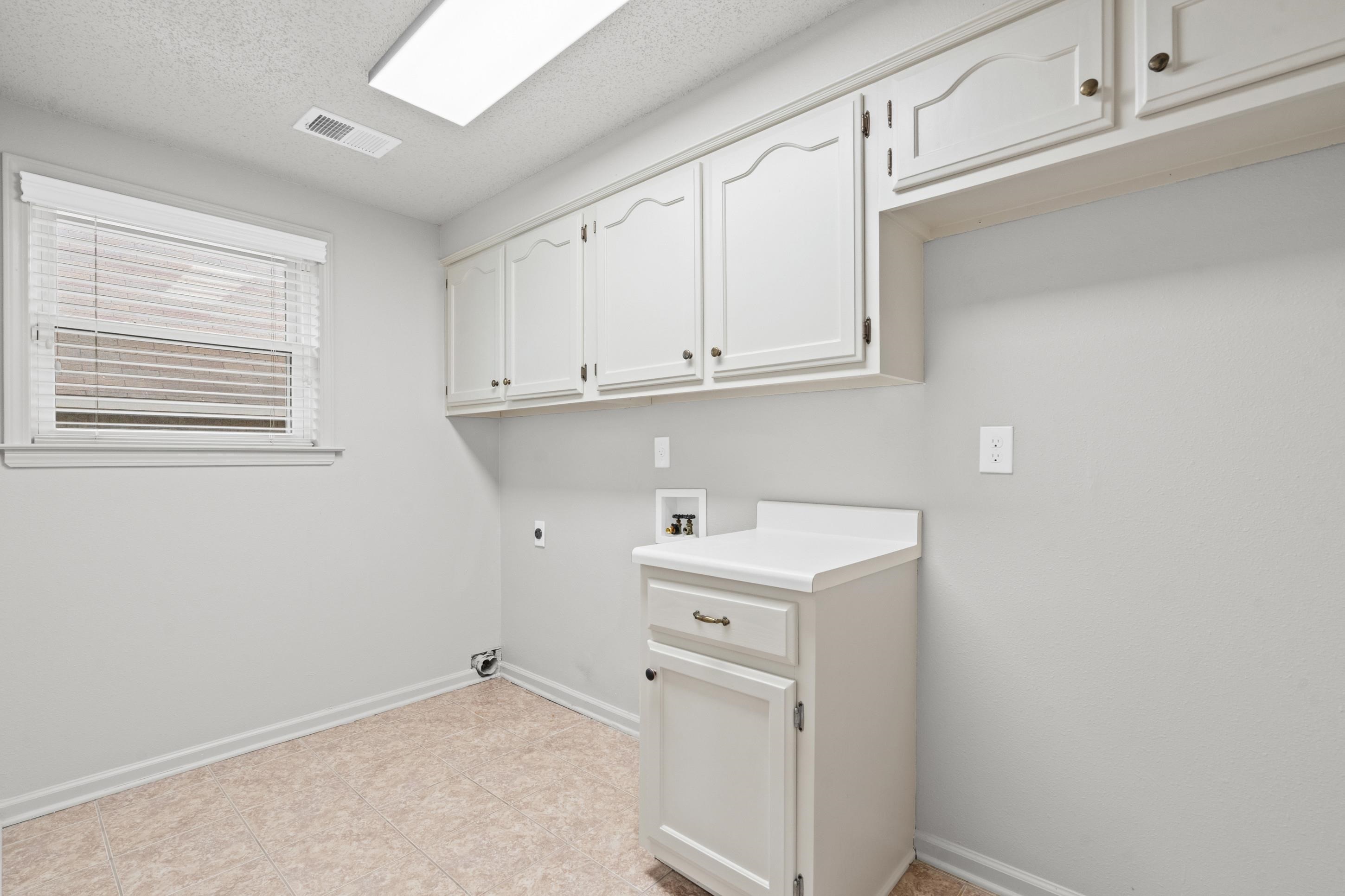 1301 Wolf Lair Drive Collierville, TN 38017 - Photo 8 of 32 Laundry area featuring a textured ceiling, washer hookup, hookup for an electric dryer, and cabinet space