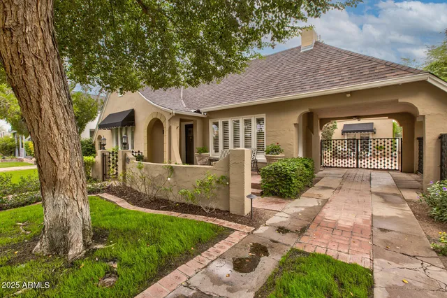 a front view of a house with a yard and potted plants