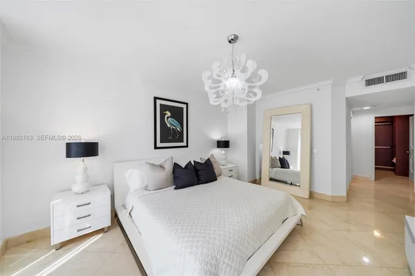 a bedroom with bed and a chandelier