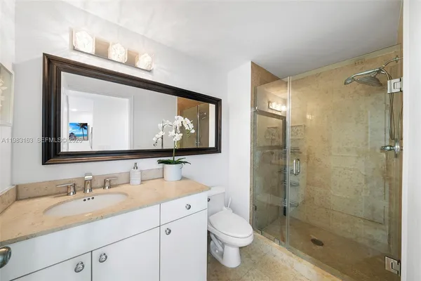 a bathroom with a toilet sink double vanity and shower