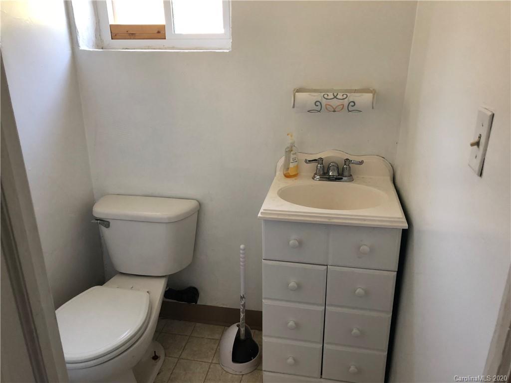 2813 Lowell Road Gastonia, NC 28054 - Photo 4 of 4 a bathroom with a toilet sink and mirror