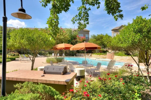 a view of a swimming pool with a patio and plants