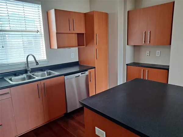 a kitchen with granite countertop a sink a stove and cabinets