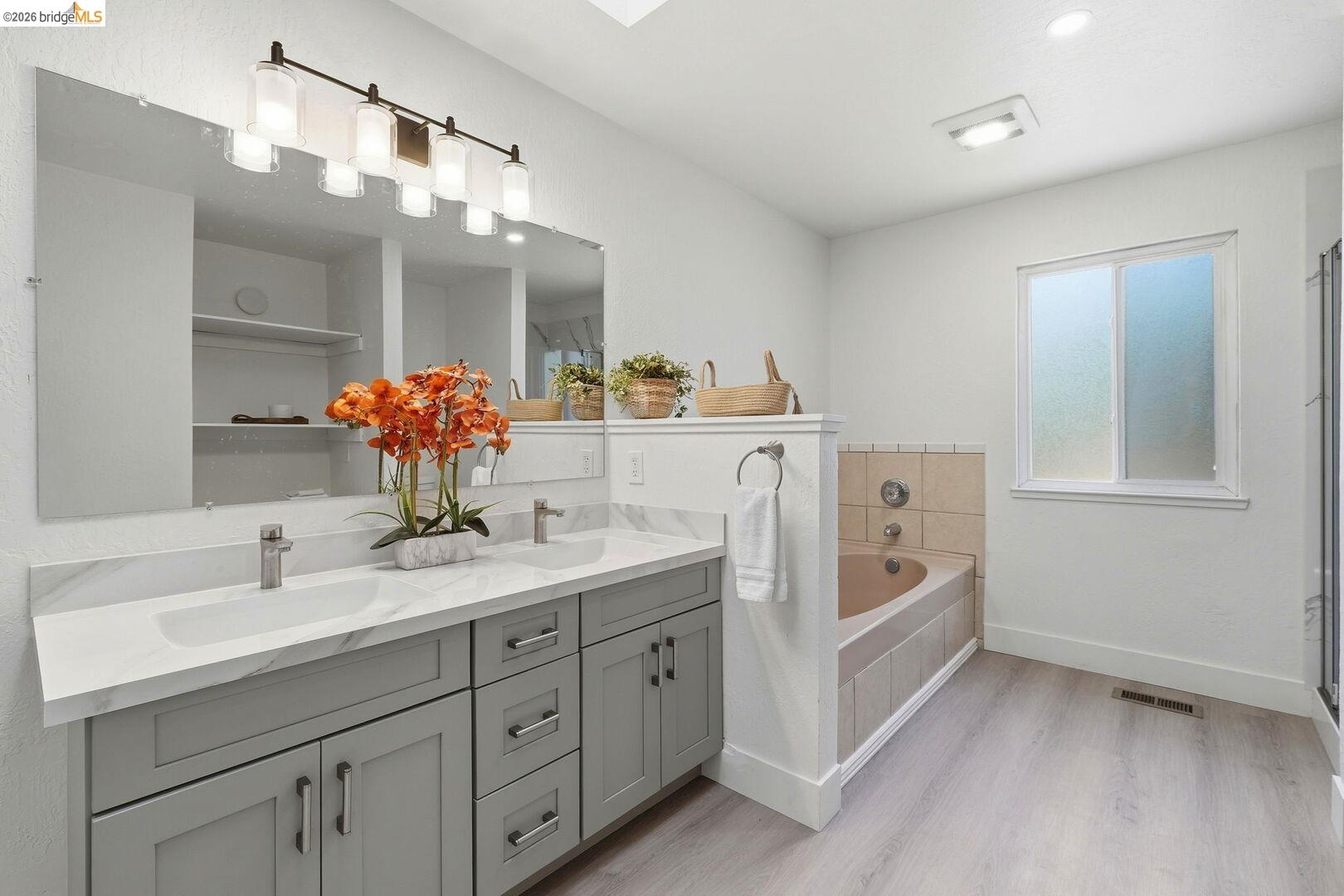 1590 Sunset Road Brentwood, CA 94513 - Photo 23 of 45 Dual vanity with gray shaker cabinetry, undermount sinks, and a white marble-finish countertop