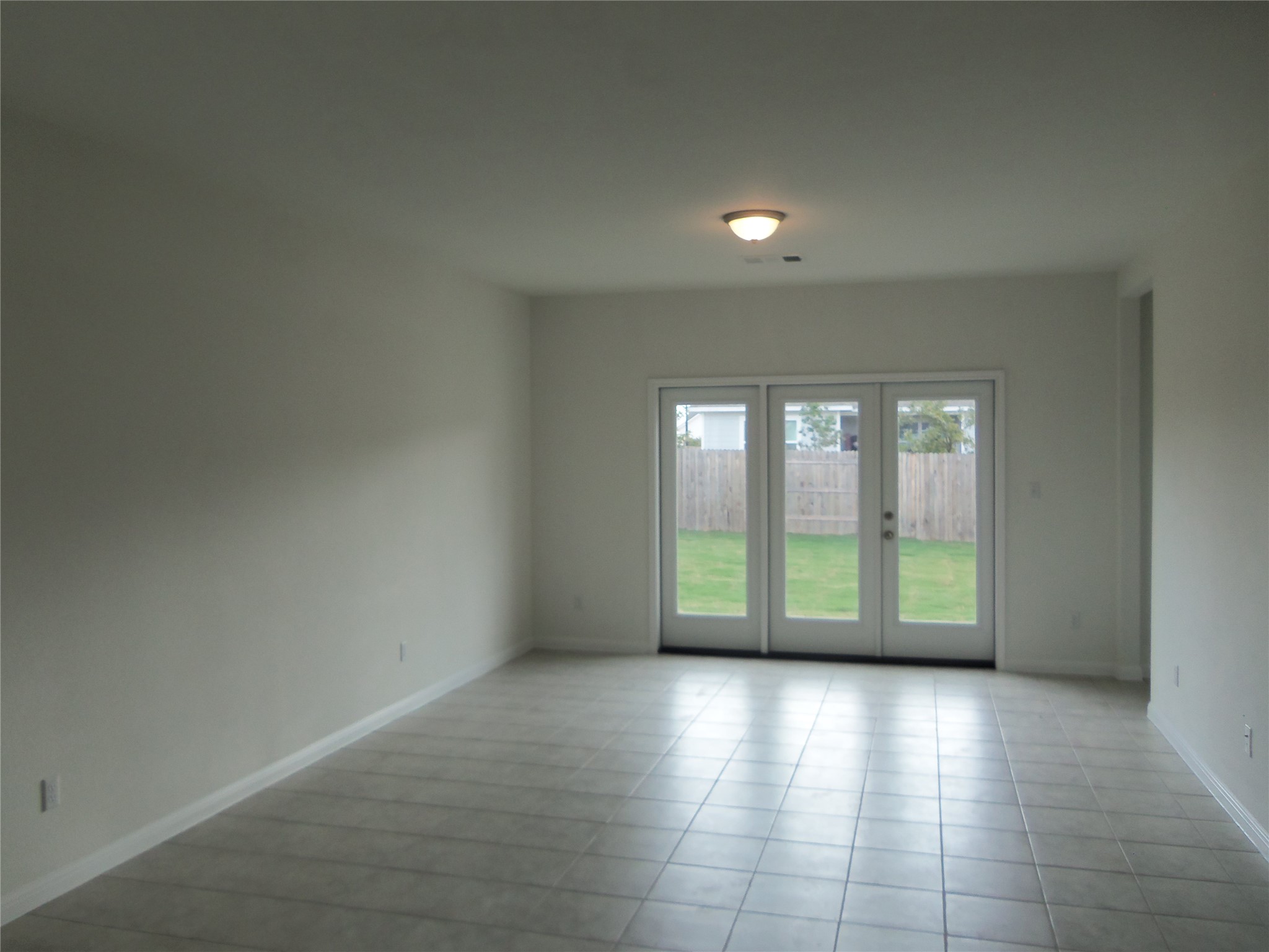 303 Cold Springs Loop Bastrop, TX 78602 - Photo 3 of 13 Patio doors open to a fenced yard, creating an inviting indoor-outdoor flow.