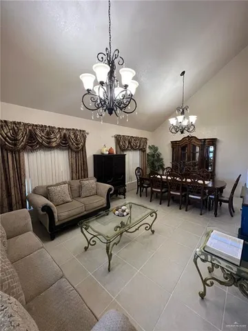 a living room with furniture chandelier and a table