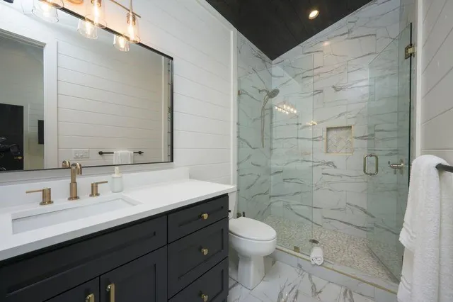 a bathroom with a sink a toilet and shower