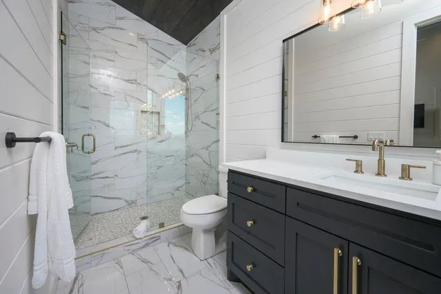 a bathroom with a sink toilet a mirror and shower