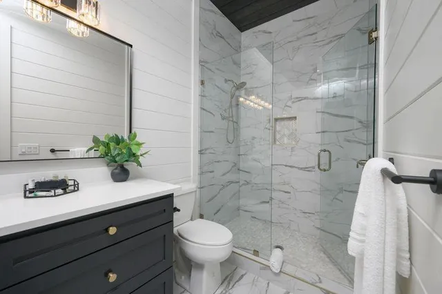 a bathroom with a sink a toilet and shower