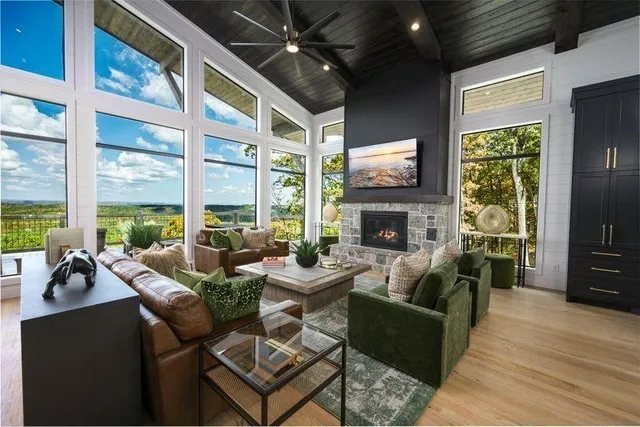 a living room with fireplace furniture and a large window
