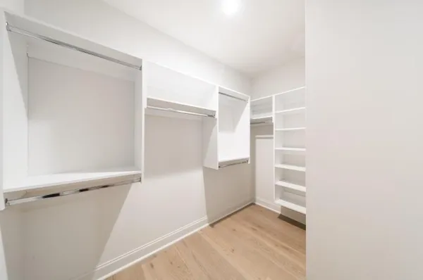 a view of walk in closet with empty racks