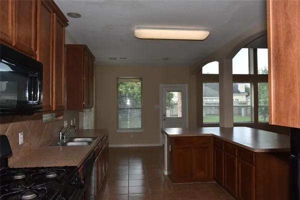 a kitchen with stainless steel appliances granite countertop a sink a stove and a refrigerator