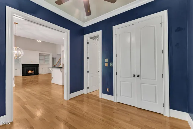a view of a hallway with wooden floor and a cabinet