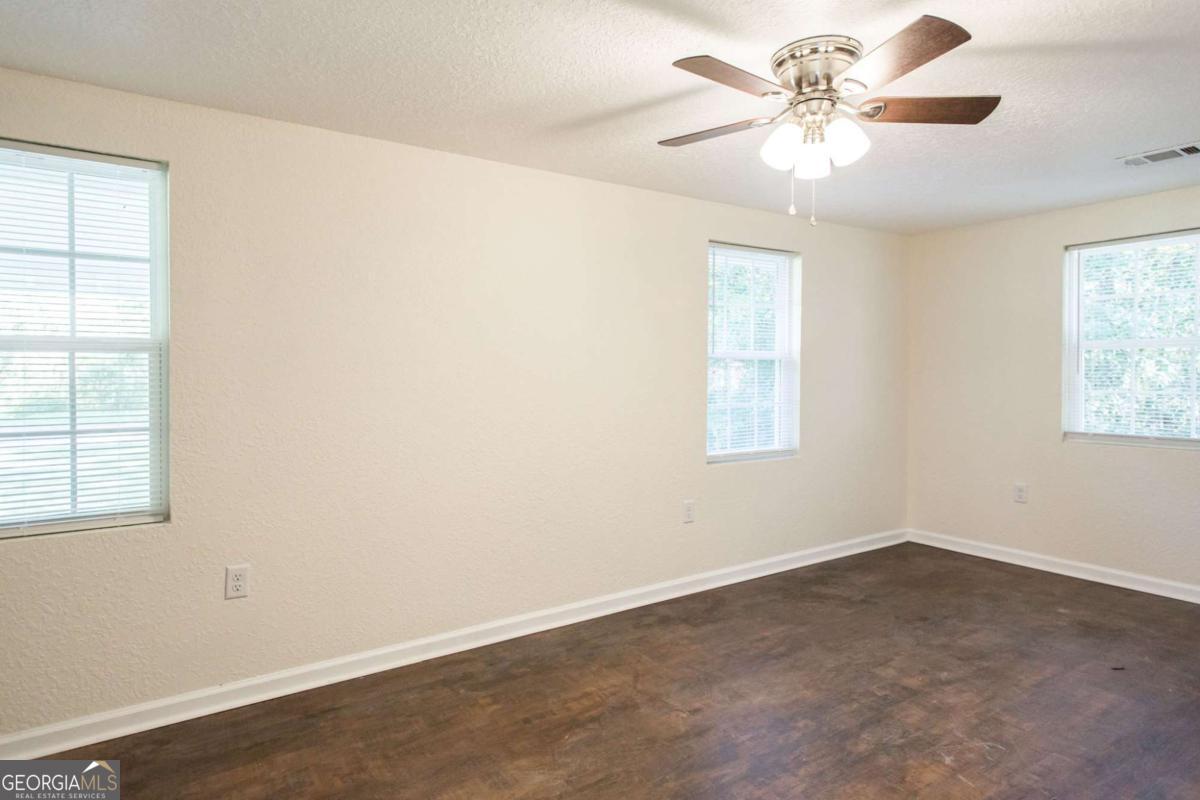 1410 Hazel Street Waycross, GA 31501 - Photo 17 of 21 an empty room with windows and fan