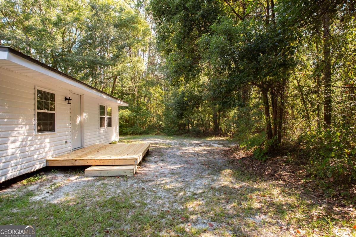 1410 Hazel Street Waycross, GA 31501 - Photo 4 of 21 a view of backyard with large trees