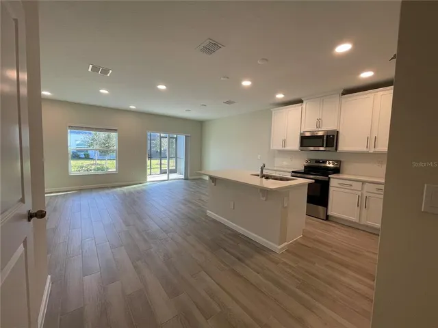 a kitchen with a refrigerator and a stove top oven