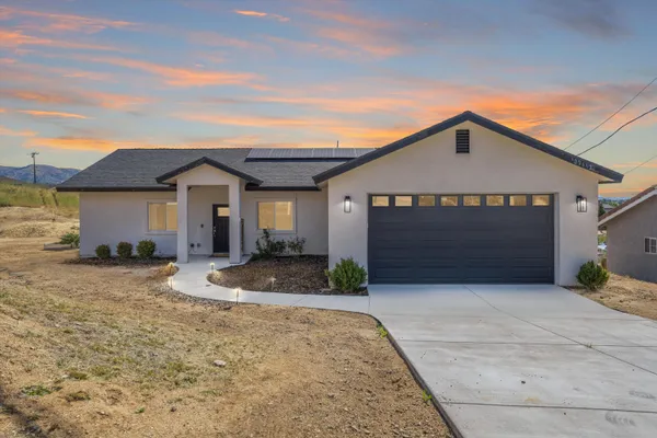 a front view of a house with a yard and garage