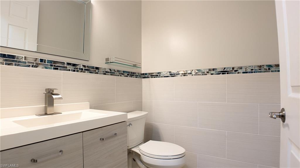 9067 Capistrano Street North, Unit 4503 Naples, FL 34113 - Photo 12 of 41 a bathroom with a sink mirror vanity and toilet