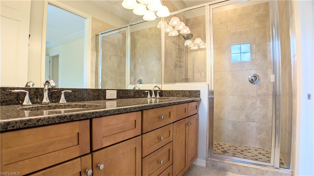 9067 Capistrano Street North, Unit 4503 Naples, FL 34113 - Photo 17 of 41 a bathroom with a granite countertop sink and a mirror