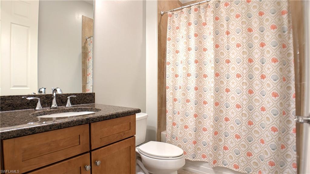 9067 Capistrano Street North, Unit 4503 Naples, FL 34113 - Photo 21 of 41 a bathroom with a granite countertop sink mirror vanity and toilet