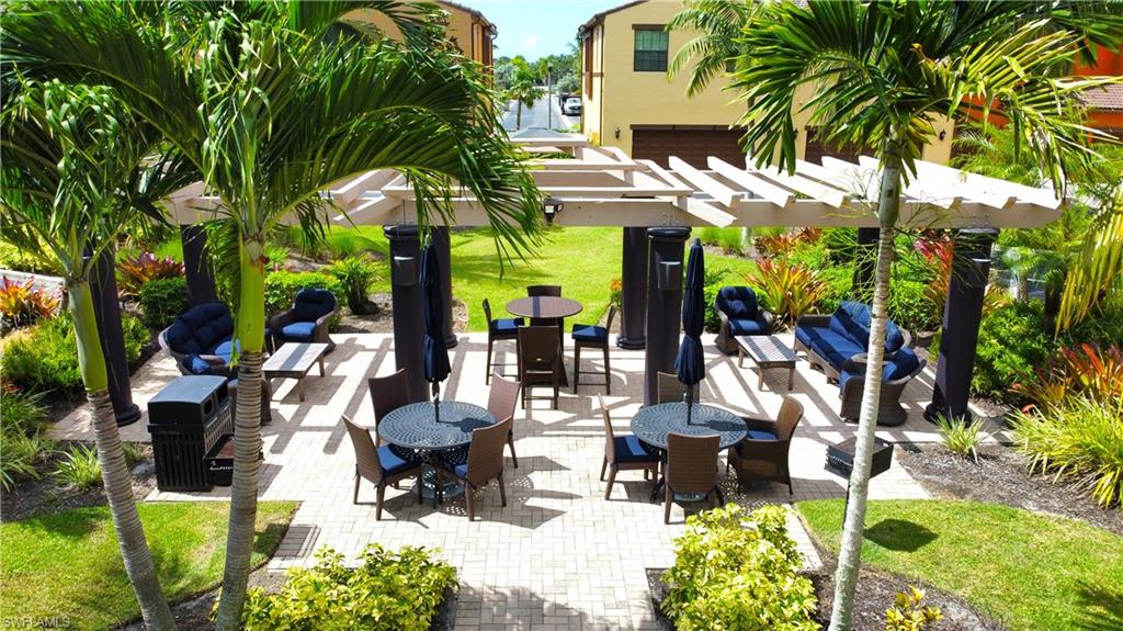 9067 Capistrano Street North, Unit 4503 Naples, FL 34113 - Photo 26 of 41 a view of a patio with table and chairs potted plants