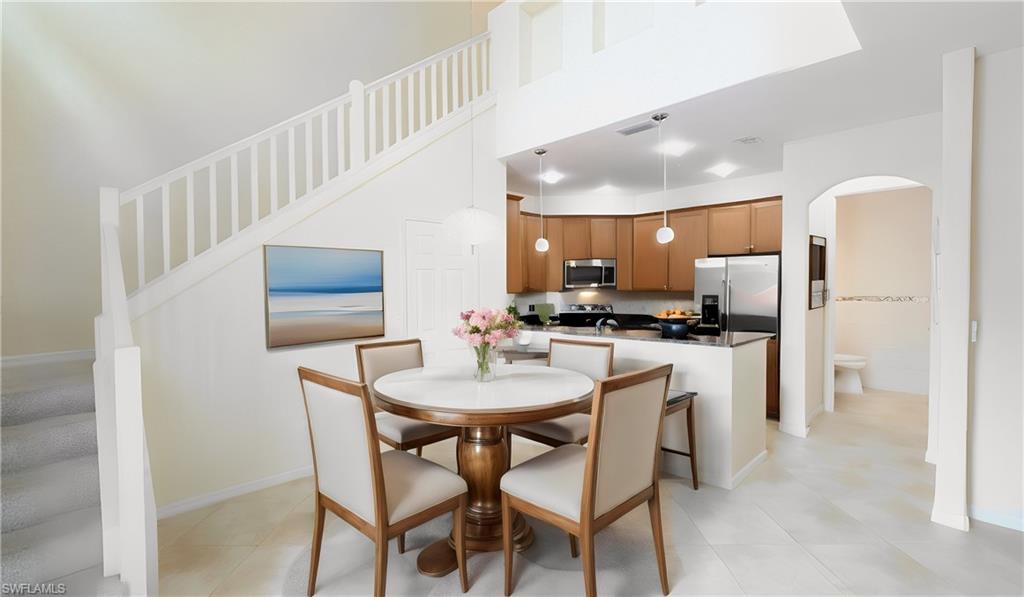 9067 Capistrano Street North, Unit 4503 Naples, FL 34113 - Photo 4 of 41 a kitchen with refrigerator and chairs
