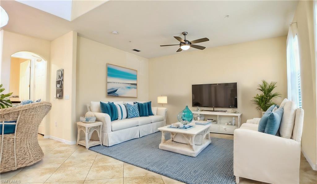 9067 Capistrano Street North, Unit 4503 Naples, FL 34113 - Photo 6 of 41 a living room with furniture a flat screen tv and a potted plant