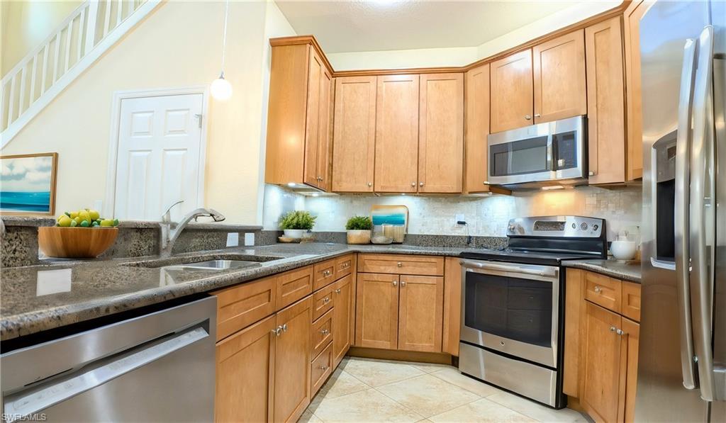 9067 Capistrano Street North, Unit 4503 Naples, FL 34113 - Photo 8 of 41 a kitchen with stainless steel appliances granite countertop a sink stove and microwave