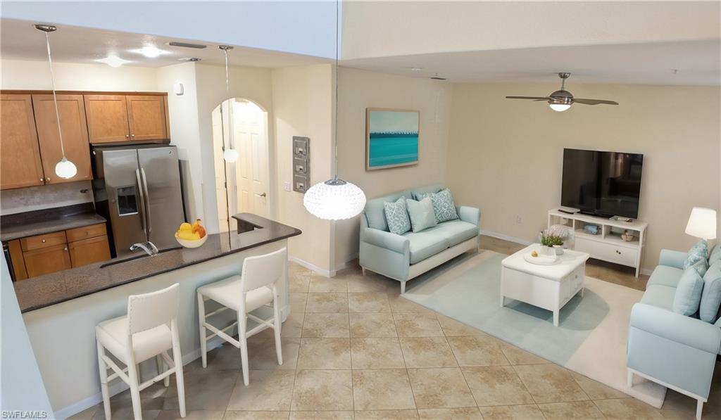 9067 Capistrano Street North, Unit 4503 Naples, FL 34113 - Photo 10 of 41 a living room with furniture and a flat screen tv