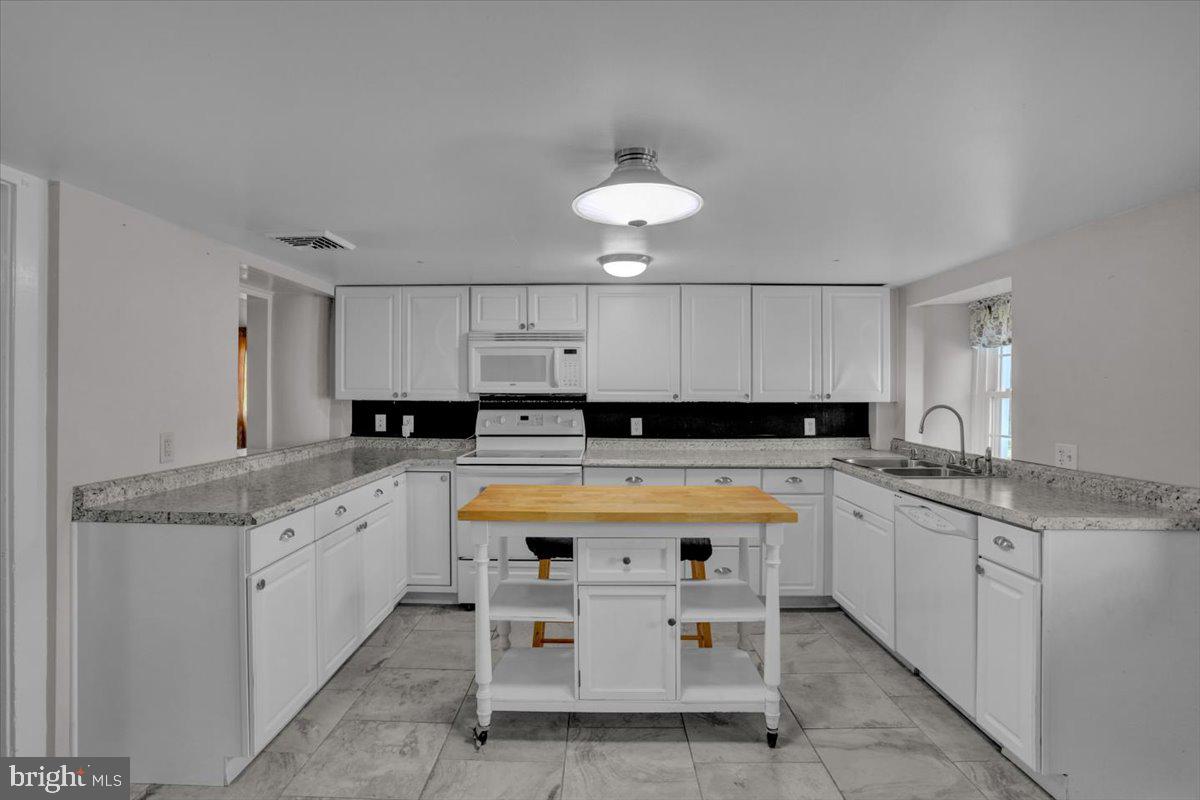 739 Boar Road Mohrsville, PA 19541 - Photo 65 of 98 a kitchen with stainless steel appliances granite countertop a sink and dishwasher a stove top oven with white cabinets