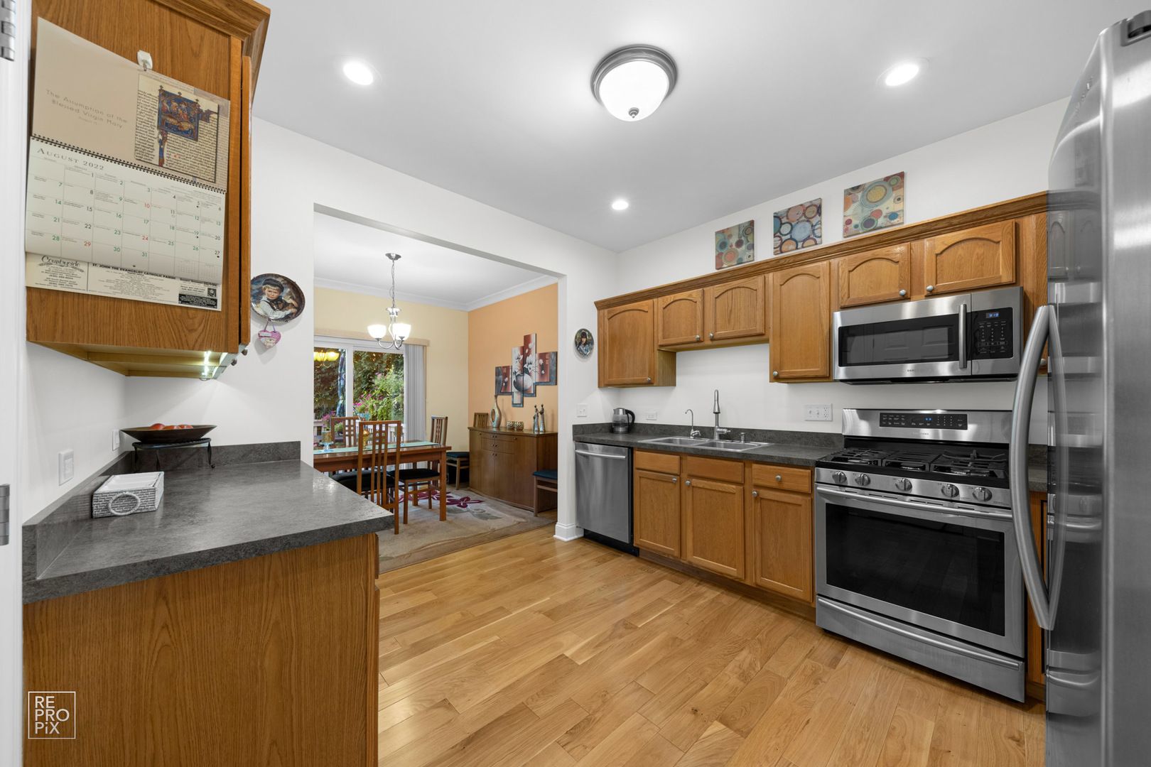 Undisclosed Address Elgin, IL 60120 - Photo 9 of 22 a kitchen with stainless steel appliances granite countertop a stove top oven a sink a dining table and chairs