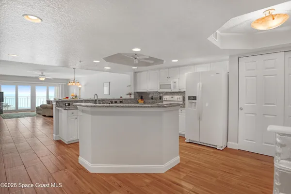 a kitchen with stainless steel appliances granite countertop a refrigerator a sink and a stove