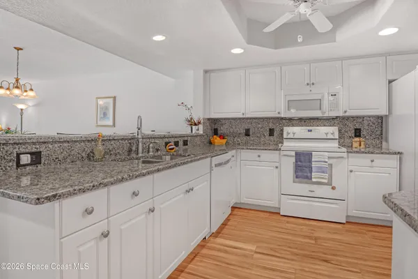 a kitchen with white cabinets appliances and a sink