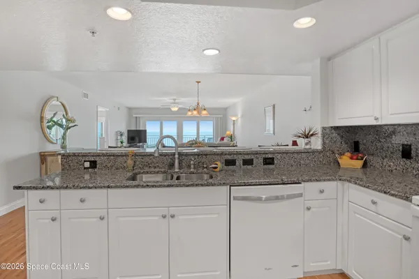 a kitchen with stainless steel appliances granite countertop a sink and a white cabinets