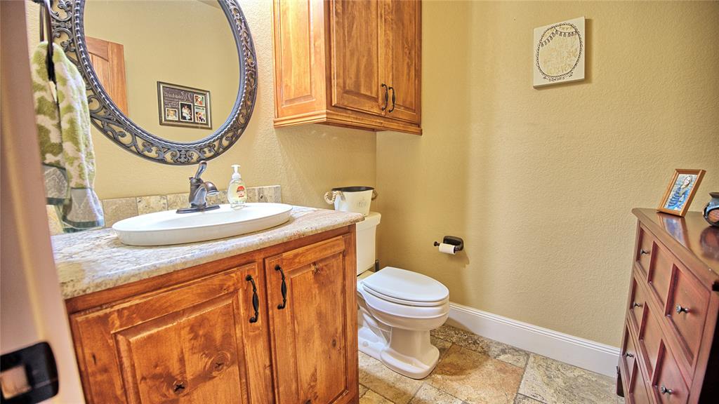 202 Storey Road Nocona, TX 76255 - Photo 15 of 40 a bathroom with a sink a toilet and a mirror