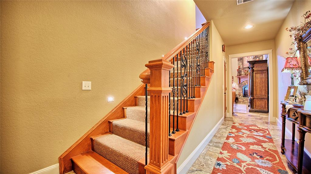 202 Storey Road Nocona, TX 76255 - Photo 19 of 40 a view of staircase with lots of frames on wall and a rug