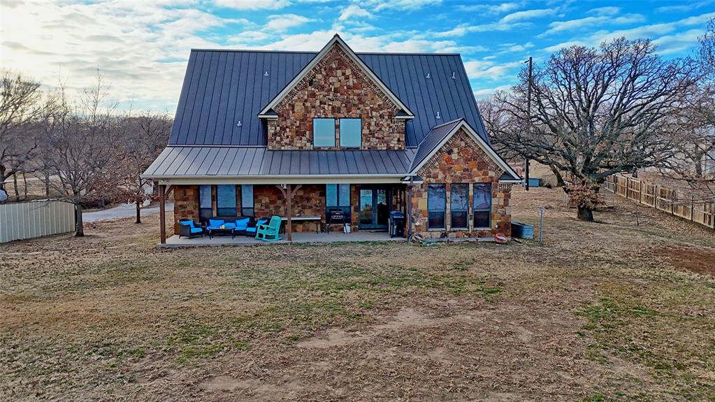 202 Storey Road Nocona, TX 76255 - Photo 28 of 40 a view of a large house with large tree and wooden fence