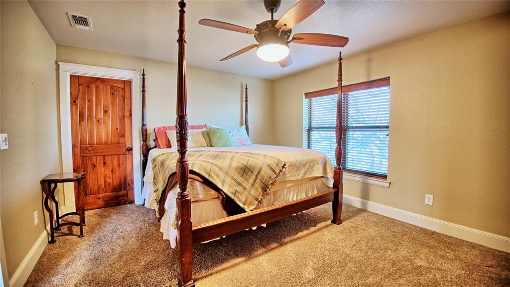 202 Storey Road Nocona, TX 76255 - Photo 31 of 40 a bedroom with a bed and a chandelier