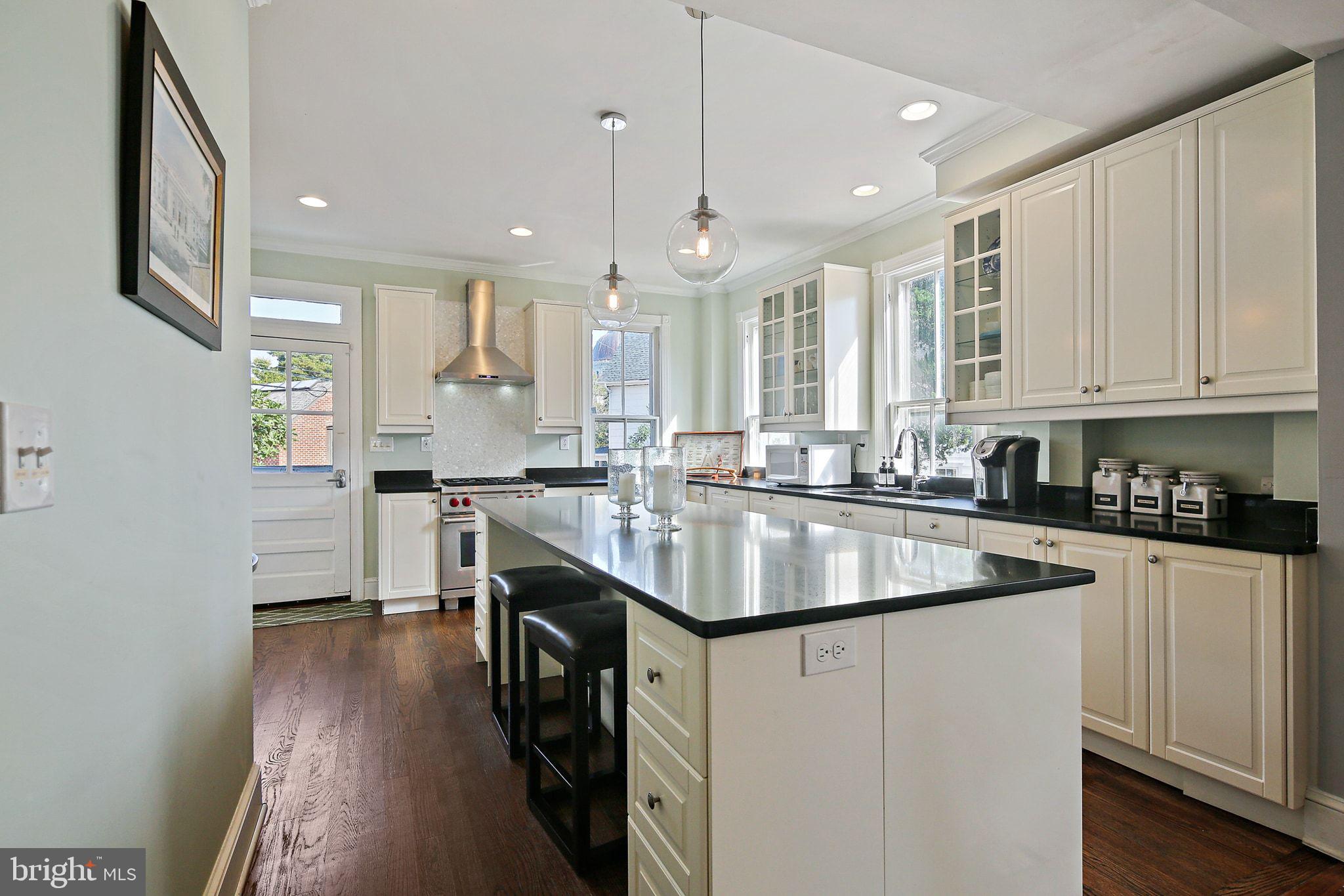 32 East Street Annapolis, MD 21401 - Photo 15 of 34 a kitchen with kitchen island granite countertop a sink a stove and a refrigerator