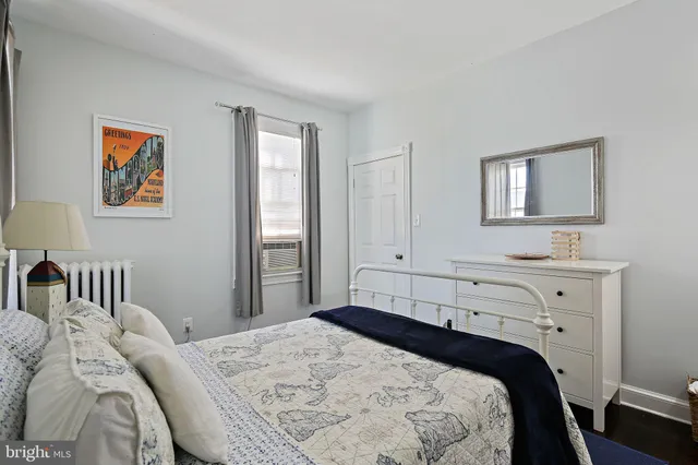 a bedroom with a bed and a lamp on dresser