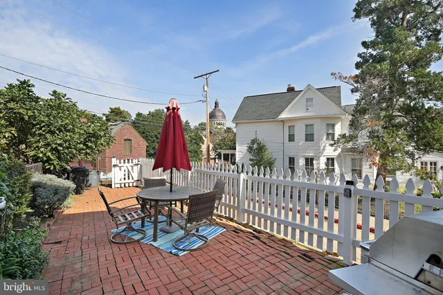 a view of a chairs and table in patio with wooden fence