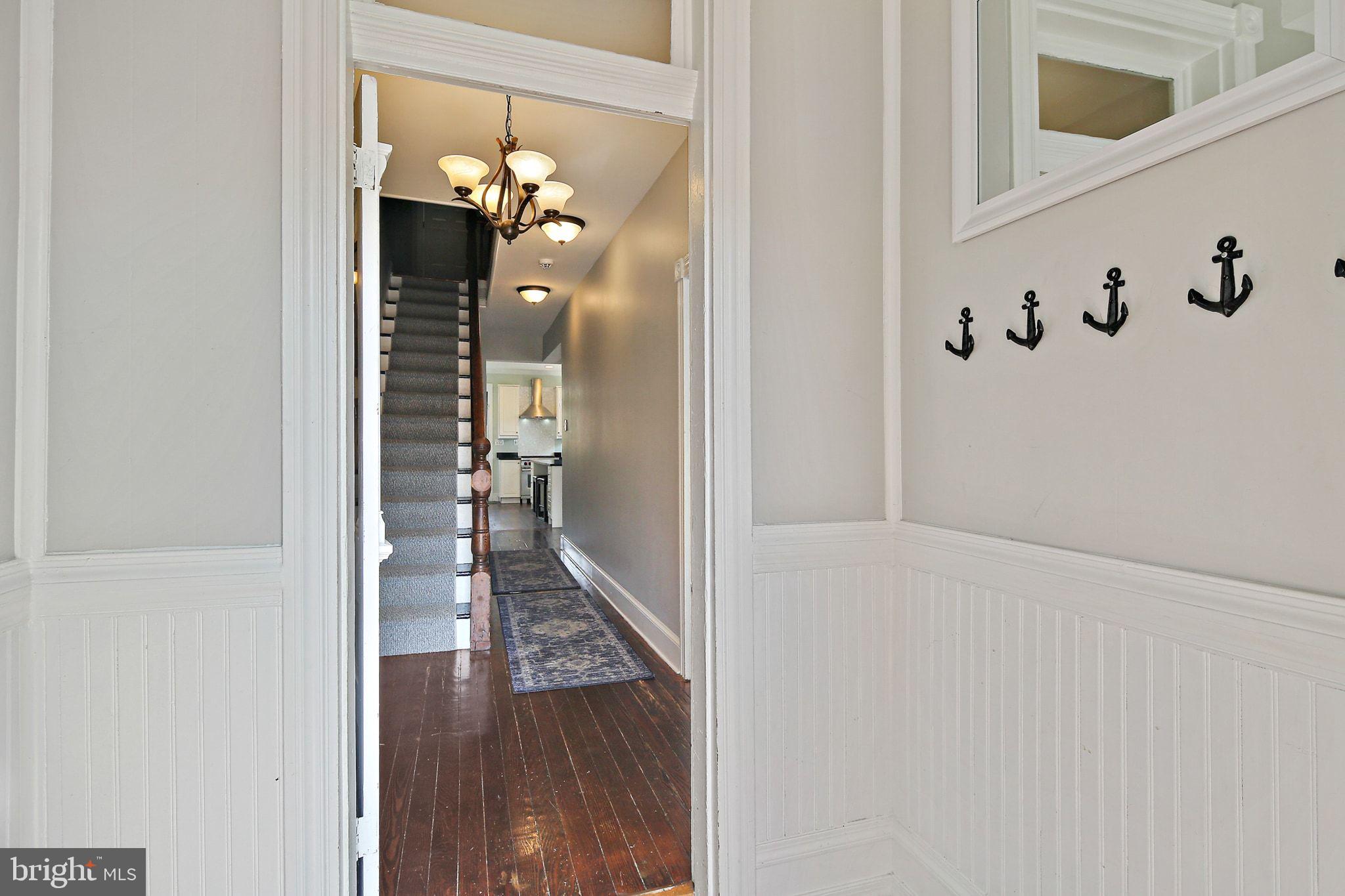 32 East Street Annapolis, MD 21401 - Photo 5 of 34 a view of a hallway with wooden floor and staircase