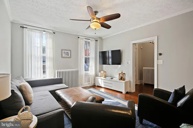 a living room with furniture ceiling fan and a window